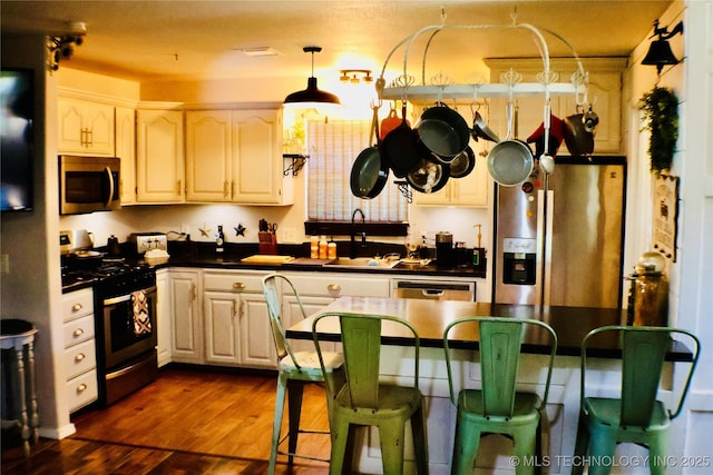330 Kiamichi, Eufaula, OK 74432 - kitchen with stainless steel appliances, dark countertops, a kitchen bar, and dark wood finished floors