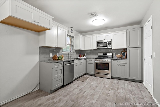 30078 E 143rd St S, Coweta, OK 74429 - kitchen featuring appliances with stainless steel finishes, light wood-style flooring, tasteful backsplash, and gray cabinetry
