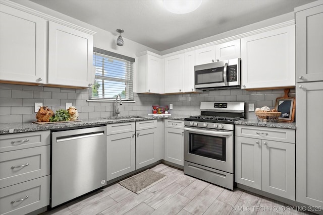 30078 E 143rd St S, Coweta, OK 74429 - kitchen with appliances with stainless steel finishes, tasteful backsplash, light stone counters, white cabinetry, and light wood-style flooring