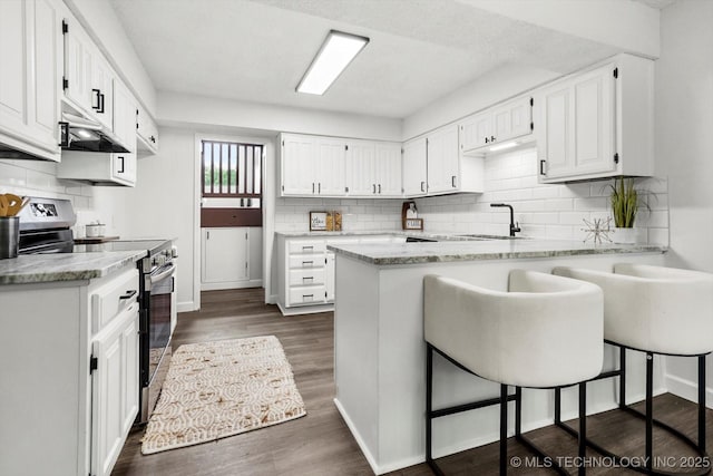 2012 N Santa Fe Ave, Tulsa, OK 74127 - kitchen featuring stainless steel electric range oven, a peninsula, backsplash, and white cabinetry