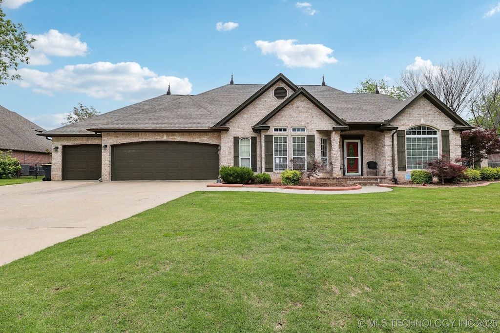 2563 E 138th Pl S, Bixby, OK 74008 - french country inspired facade featuring brick siding, a garage, a front lawn, driveway, and roof with shingles