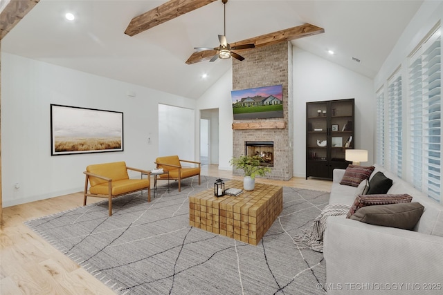 6904 E 86th Pl N, Owasso, OK 74055 - living area with beamed ceiling, light wood-type flooring, a ceiling fan, a large fireplace, and high vaulted ceiling