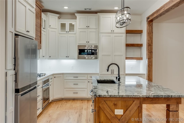 6904 E 86th Pl N, Owasso, OK 74055 - kitchen featuring stainless steel appliances, open shelves, white cabinets, light wood-style floors, and hanging light fixtures