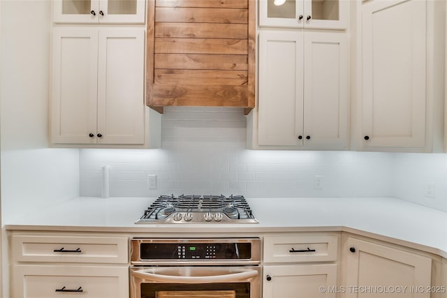 6904 E 86th Pl N, Owasso, OK 74055 - kitchen featuring appliances with stainless steel finishes, light countertops, glass insert cabinets, and white cabinetry