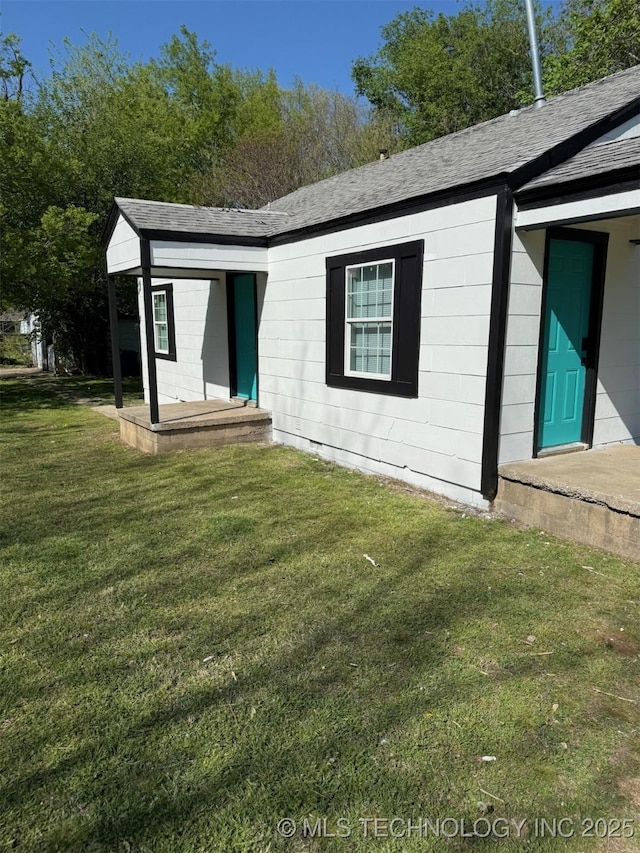 2705 E Ute St, Tulsa, OK 74110 - back of property with a shingled roof and a lawn