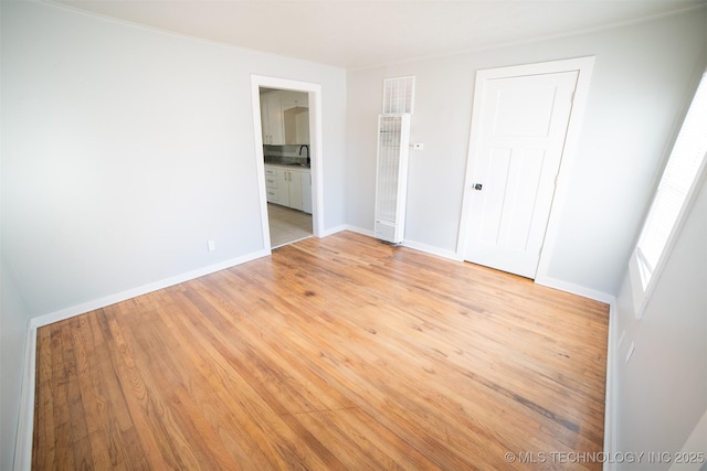 2705 E Ute St, Tulsa, OK 74110 - unfurnished bedroom featuring light wood-type flooring, a heating unit, connected bathroom, and a closet
