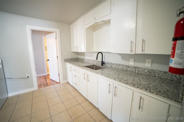 2705 E Ute St, Tulsa, OK 74110 - kitchen featuring crown molding, white cabinets, light tile patterned flooring, and light stone countertops