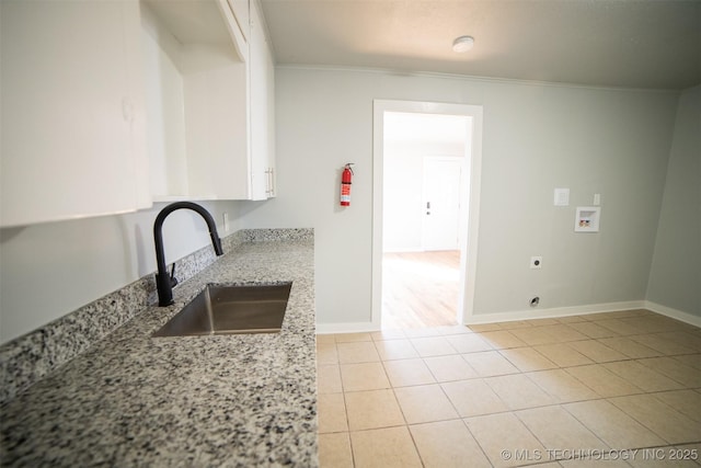 2705 E Ute St, Tulsa, OK 74110 - kitchen featuring white cabinets, light stone counters, ornamental molding, and light tile patterned flooring
