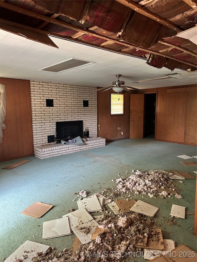 1581 S Velma, Atoka, OK 74525 - unfurnished living room featuring a fireplace, wooden walls, and carpet flooring