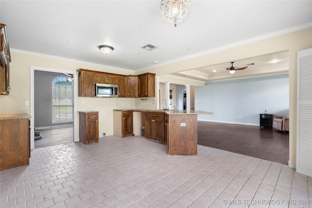 5764 S Carr, Pen, OK 74525 - kitchen featuring stainless steel microwave, open floor plan, a peninsula, ornamental molding, and light countertops