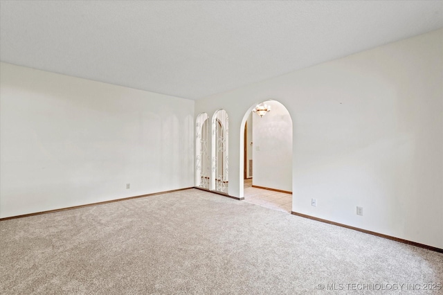 1020 Lariat Dr, Bartlesville, OK 74006 - empty room with light carpet and arched walkways