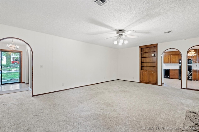 1020 Lariat Dr, Bartlesville, OK 74006 - carpeted empty room with arched walkways, a chandelier, a ceiling fan, a textured ceiling, and built in features