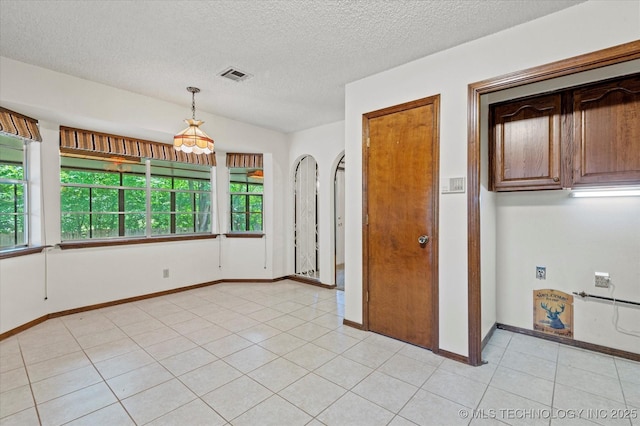 1020 Lariat Dr, Bartlesville, OK 74006 - spare room with arched walkways, a textured ceiling, and light tile patterned floors