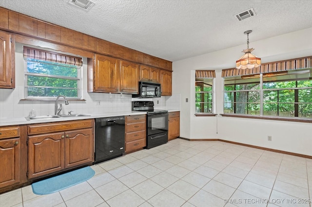 1020 Lariat Dr, Bartlesville, OK 74006 - kitchen featuring black appliances, backsplash, light countertops, brown cabinetry, and a textured ceiling