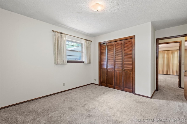 1020 Lariat Dr, Bartlesville, OK 74006 - unfurnished bedroom with carpet floors, a textured ceiling, and a closet