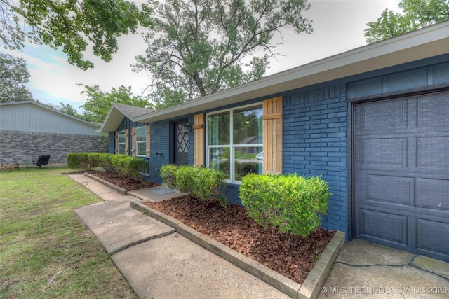 13306 E 28th St, Tulsa, OK 74134 - property entrance with brick siding, a lawn, and an attached garage