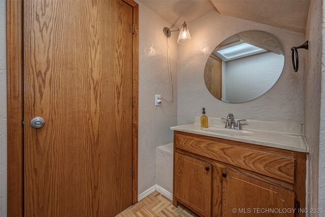 2676 Masters, Sulphur, OK 73086 - bathroom featuring vanity, a textured wall, and vaulted ceiling