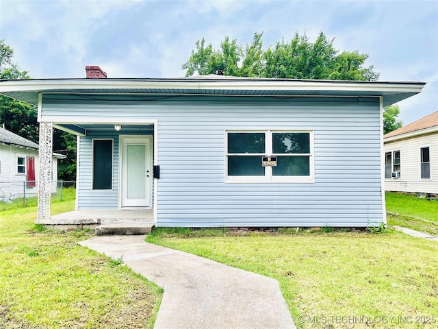 910 N Collins St, Okmulgee, OK 74447 - view of front of property with covered porch, a front yard, and a chimney