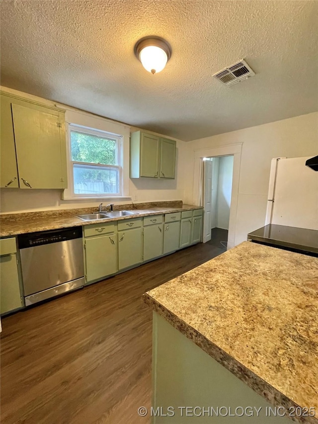910 N Collins St, Okmulgee, OK 74447 - kitchen featuring stainless steel dishwasher, green cabinets, a textured ceiling, dark wood-style flooring, and freestanding refrigerator