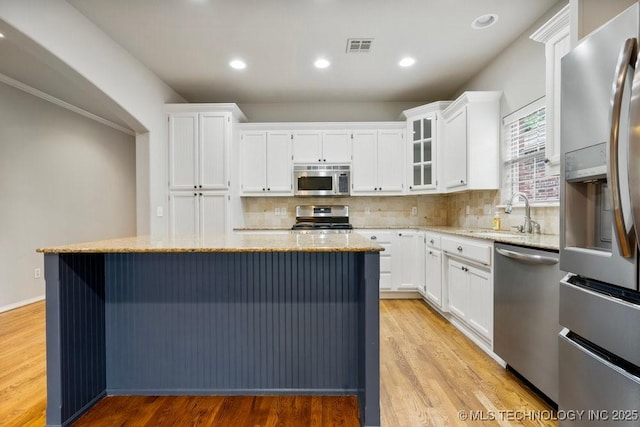 9929 S 85th E Ave, Tulsa, OK 74133 - kitchen featuring stainless steel appliances, tasteful backsplash, light stone countertops, a kitchen island, and recessed lighting