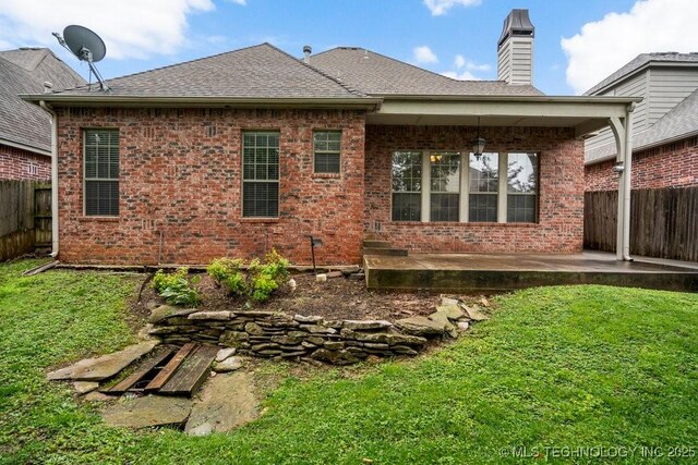 9929 S 85th E Ave, Tulsa, OK 74133 - rear view of house featuring a patio, brick siding, a chimney, and roof with shingles