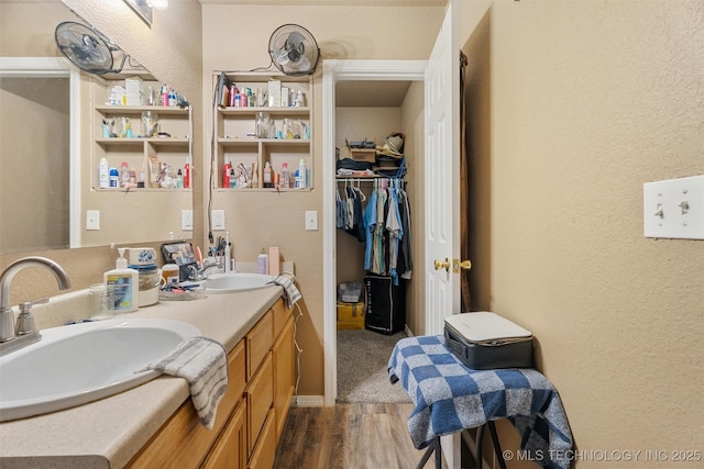 624 S Barclay, Dewey, OK 74029 - bathroom featuring wood finished floors, double vanity, a textured wall, and a spacious closet