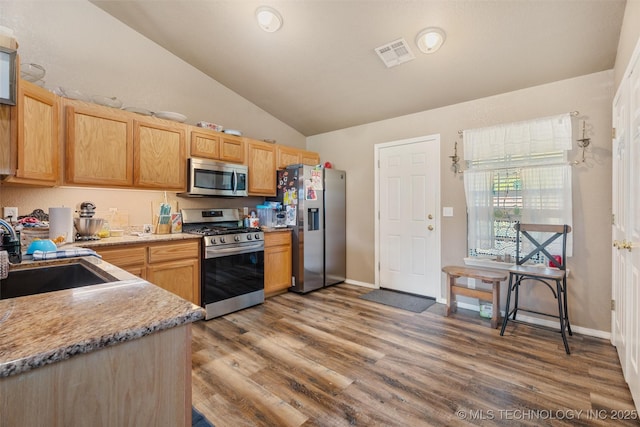 624 S Barclay, Dewey, OK 74029 - kitchen featuring stainless steel appliances, vaulted ceiling, wood finished floors, and light brown cabinets