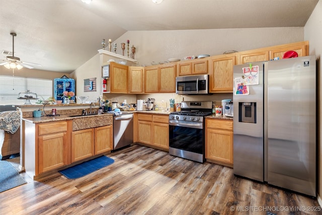 624 S Barclay, Dewey, OK 74029 - kitchen featuring stainless steel appliances, vaulted ceiling, a peninsula, a ceiling fan, and light wood-type flooring