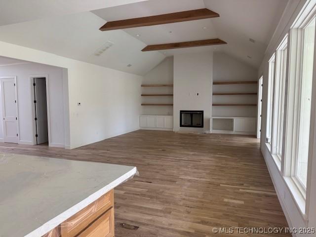 10204 S Florence Ave, Tulsa, OK 74137 - unfurnished living room featuring light wood-type flooring, a fireplace, and built in features