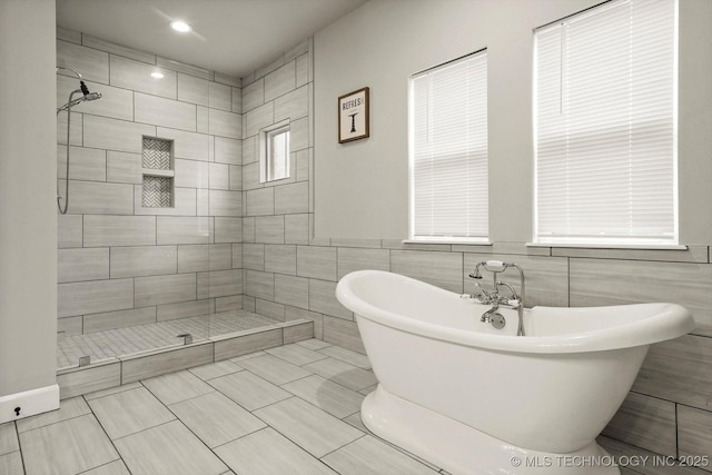 14271 S College Ave, Bixby, OK 74008 - bathroom featuring a freestanding bath, a tile shower, and tile walls