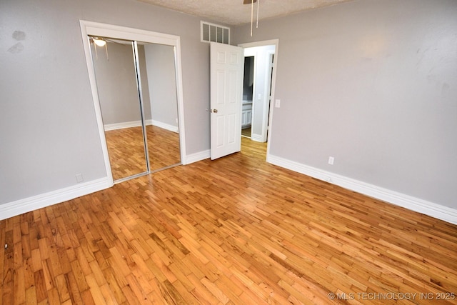 1107 Hillcrest Ave, Tahlequah, OK 74464 - unfurnished bedroom featuring light wood-type flooring, a closet, and a textured ceiling