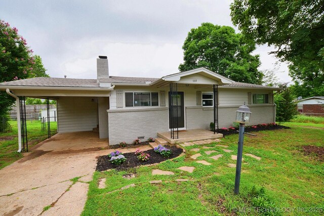 1107 Hillcrest Ave, Tahlequah, OK 74464 - ranch-style home with a chimney, an attached carport, concrete driveway, and brick siding