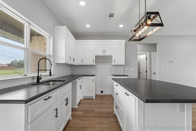 59 Michael, Durant, OK 74730 - kitchen featuring dark countertops, dark wood-style floors, recessed lighting, backsplash, and a kitchen island