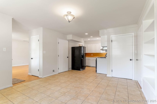 1632 E 55th Pl, Tulsa, OK 74105 - kitchen with black fridge with ice dispenser, white range oven, white cabinets, light tile patterned floors, and wall chimney exhaust hood