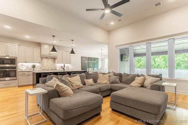 12926 S 20th Pl E, Jenks, OK 74037 - living area featuring plenty of natural light, light wood-type flooring, a ceiling fan, recessed lighting, and a chandelier