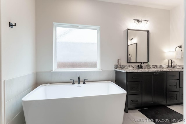 12926 S 20th Pl E, Jenks, OK 74037 - full bath featuring healthy amount of natural light, a freestanding tub, double vanity, tile patterned flooring, and tile walls