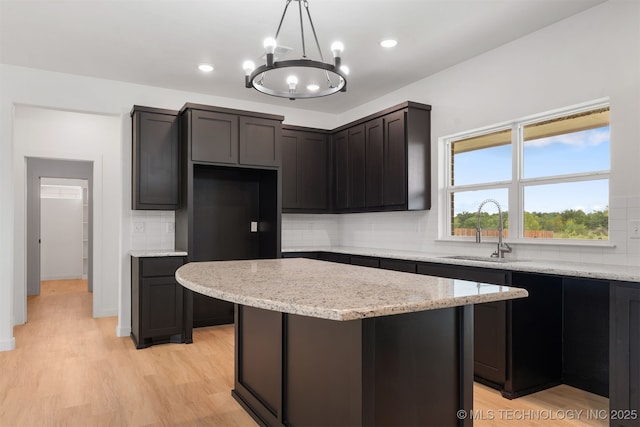 108 Michael, Calera, OK 74730 - kitchen with decorative backsplash, light wood finished floors, light stone countertops, a kitchen island, and recessed lighting