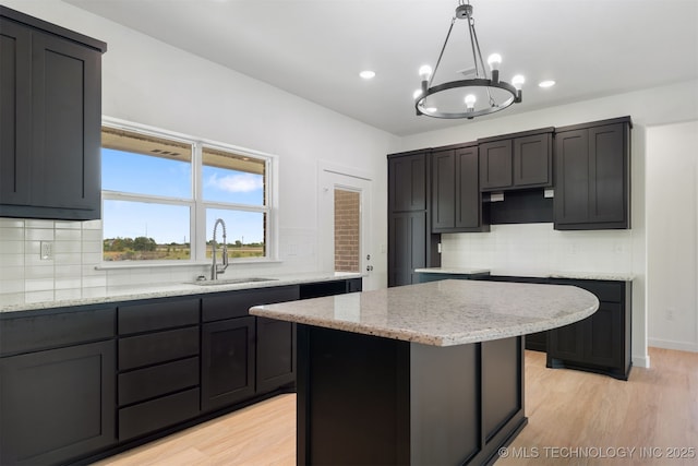 108 Michael, Calera, OK 74730 - kitchen with tasteful backsplash, light wood finished floors, a chandelier, light stone counters, and pendant lighting