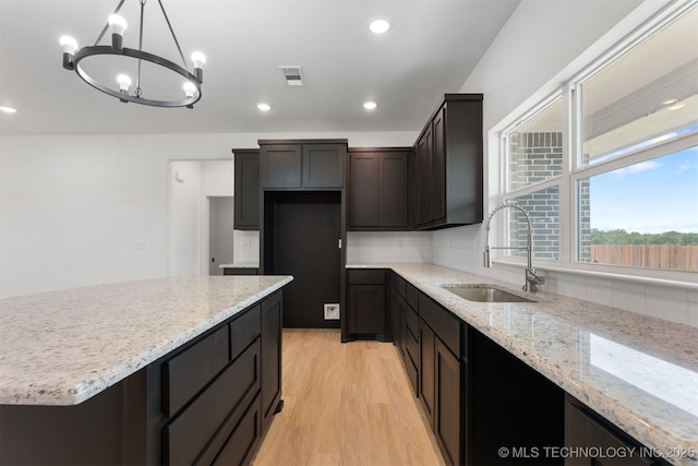 108 Michael, Calera, OK 74730 - kitchen featuring tasteful backsplash, light wood-style flooring, light stone counters, a chandelier, and recessed lighting