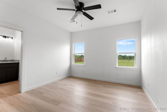 108 Michael, Calera, OK 74730 - unfurnished bedroom featuring light wood-type flooring, ensuite bathroom, and a ceiling fan