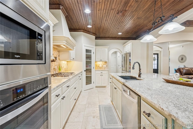 7722 N 142nd Ave E, Owasso, OK 74055 - kitchen with appliances with stainless steel finishes, custom exhaust hood, wood ceiling, arched walkways, and recessed lighting