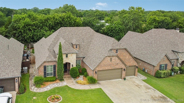 7722 N 142nd Ave E, Owasso, OK 74055 - french provincial home with a garage, brick siding, driveway, and a front yard