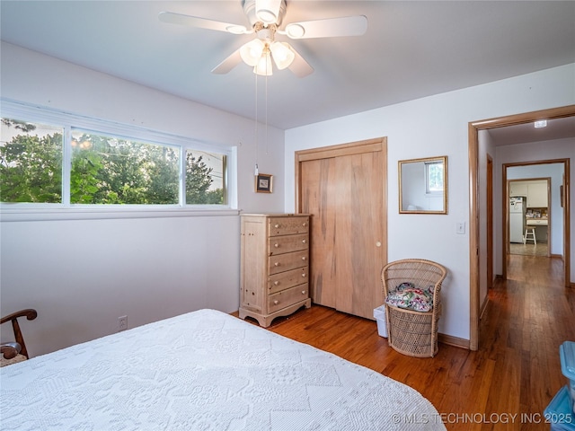 1508 E Seminole Ave, Mcalester, OK 74501 - bedroom featuring freestanding refrigerator, wood finished floors, a closet, and a ceiling fan