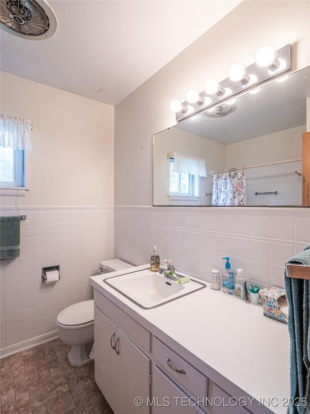 1508 E Seminole Ave, Mcalester, OK 74501 - bathroom featuring tile walls, vanity, a shower with shower curtain, and stone finish flooring