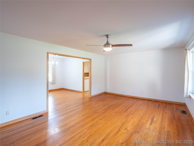 1508 E Seminole Ave, Mcalester, OK 74501 - unfurnished room with a chandelier, light wood-style flooring, and a ceiling fan