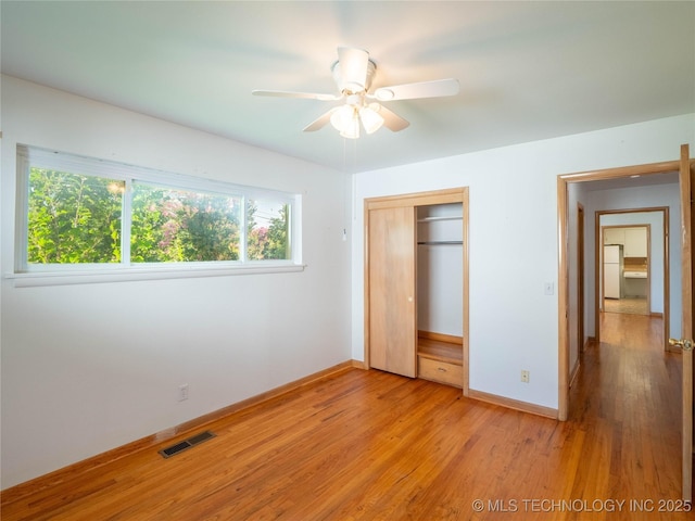 1508 E Seminole Ave, Mcalester, OK 74501 - unfurnished bedroom with freestanding refrigerator, a closet, light wood-type flooring, and ceiling fan