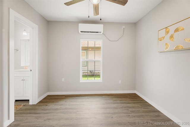 107 S Wyandotte Ave, Dewey, OK 74029 - spare room with a wall mounted AC, a ceiling fan, and wood finished floors