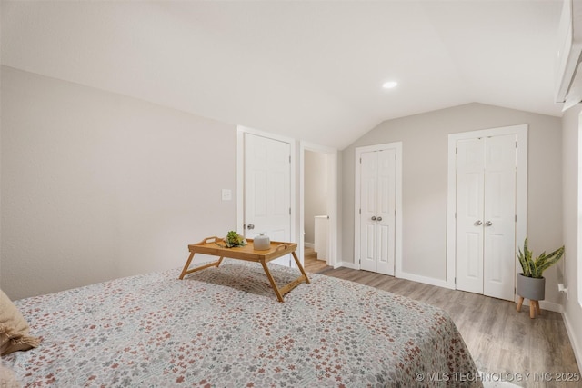 107 S Wyandotte Ave, Dewey, OK 74029 - bedroom with light wood-style flooring, multiple closets, and vaulted ceiling