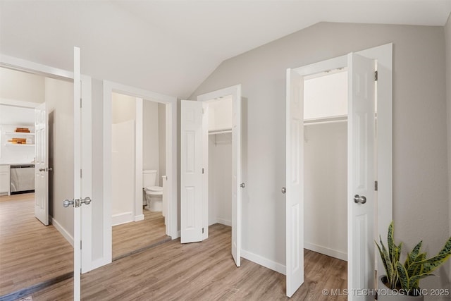 107 S Wyandotte Ave, Dewey, OK 74029 - unfurnished bedroom featuring vaulted ceiling, light wood-type flooring, and ensuite bath