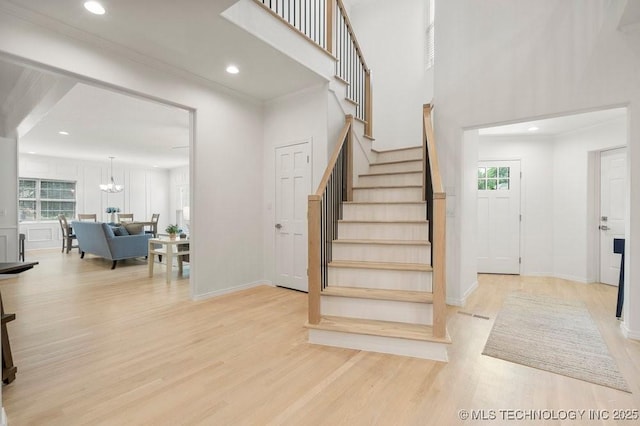 9703 S 100th E Ave, Tulsa, OK 74133 - staircase featuring wood finished floors, healthy amount of natural light, a chandelier, recessed lighting, and a towering ceiling